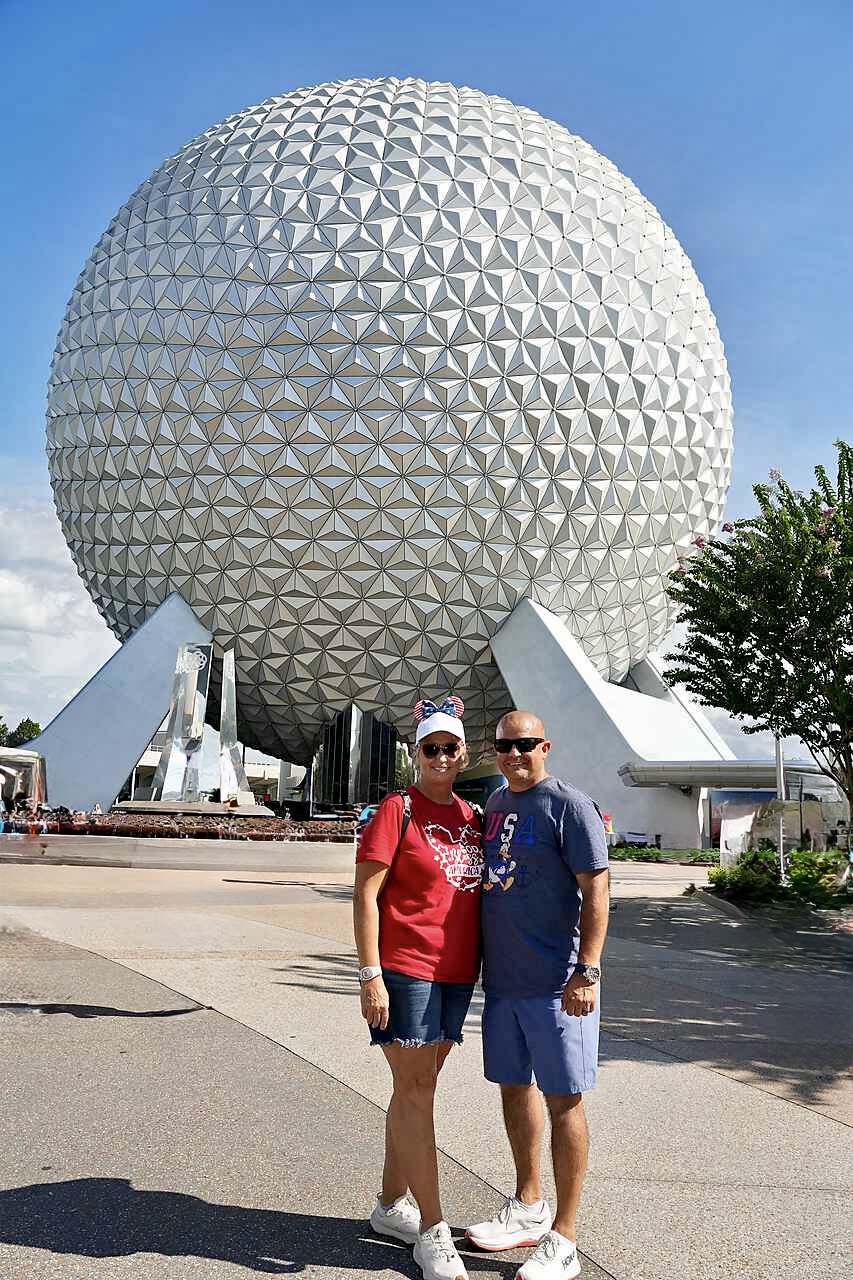 Vanessa and Troy of The Pixie Packed Family standing in front of Spaceship Earth at EPCOT