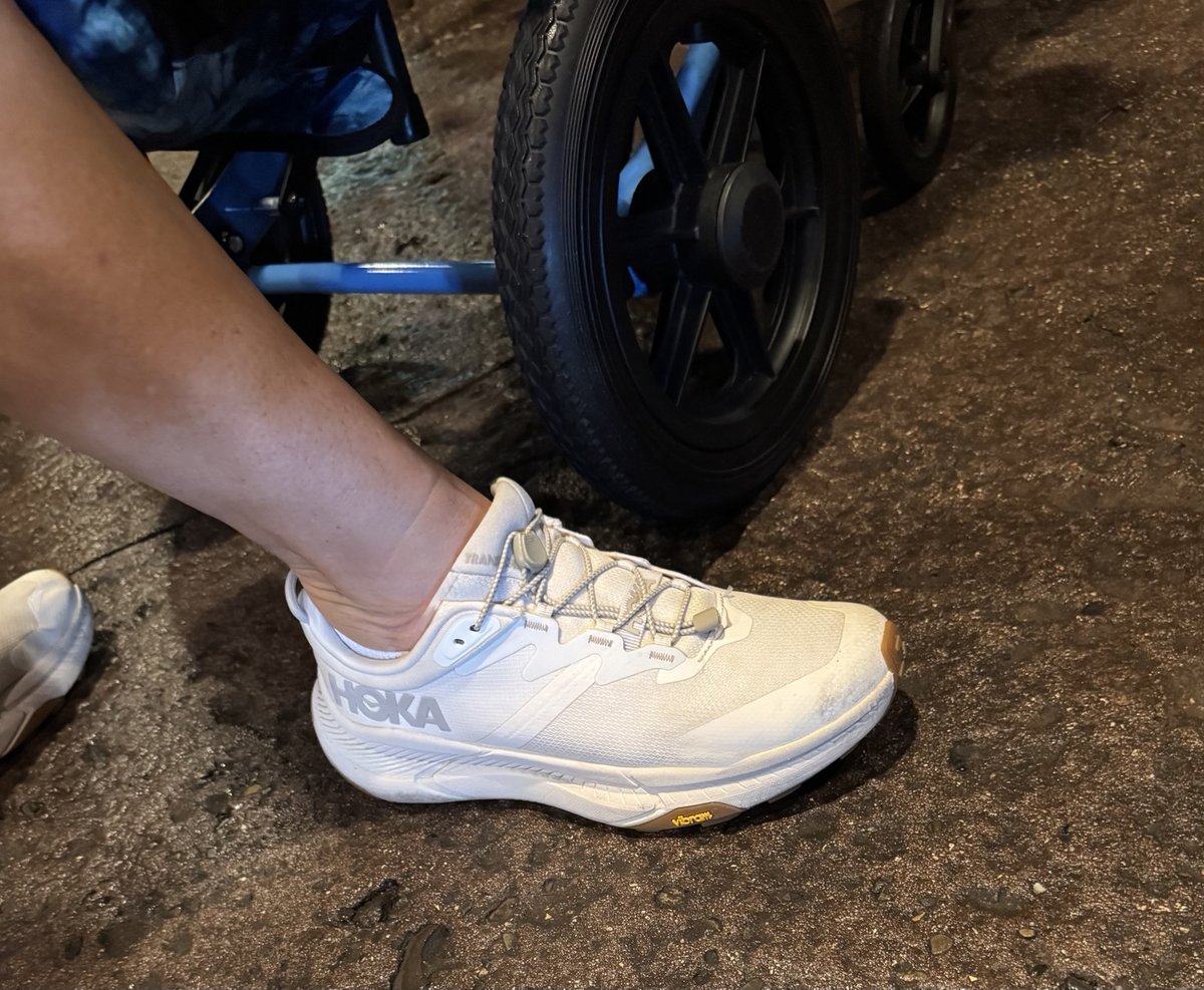 Close-up of a white Hoka shoe being worn during a Disney park day.